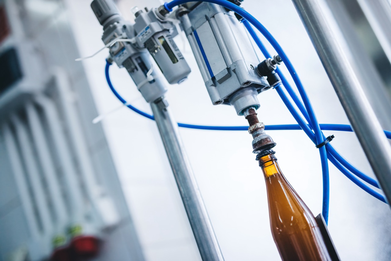 Beer bottle capping machine in brewery. Industrial