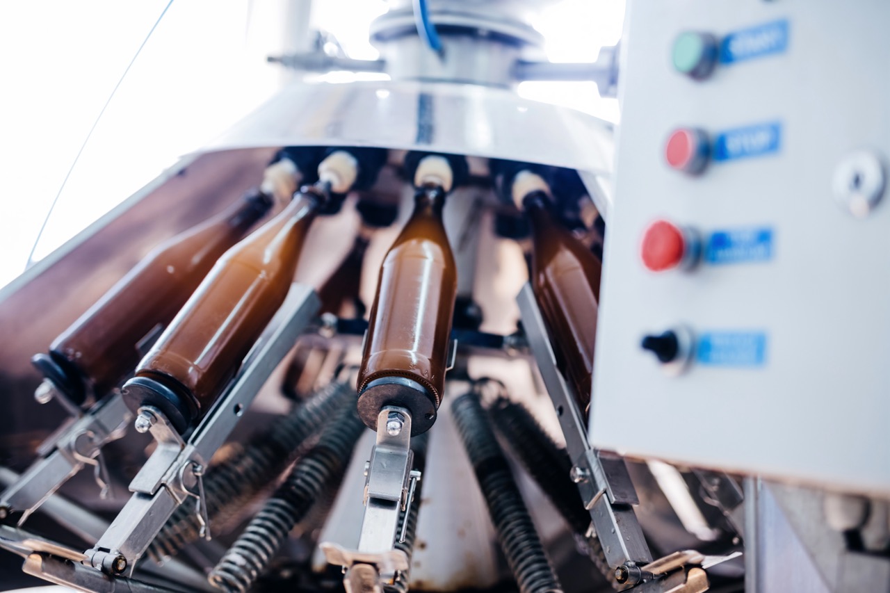 Beer bottle filling and capping machine in brewery. Industrial