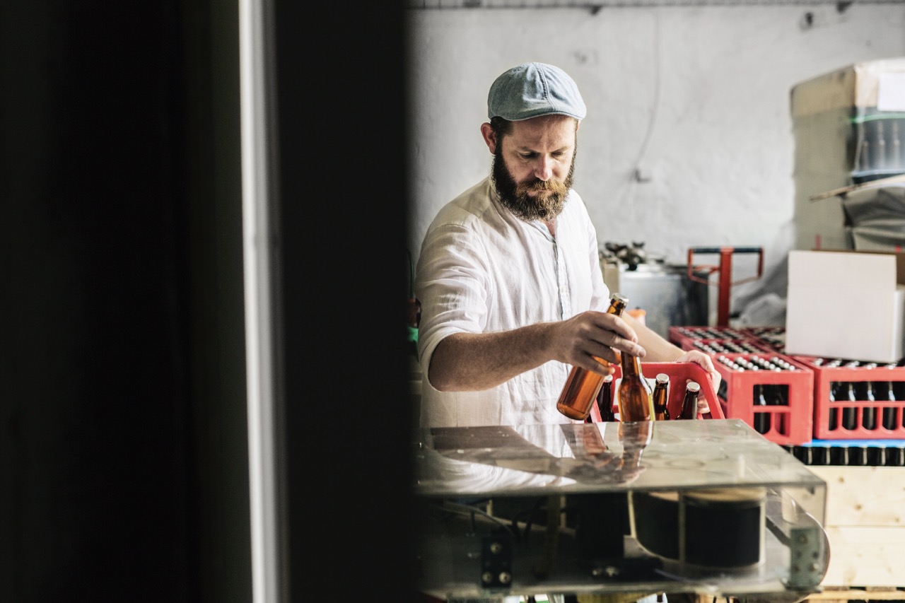 Brewery worker putting beer bottles into box